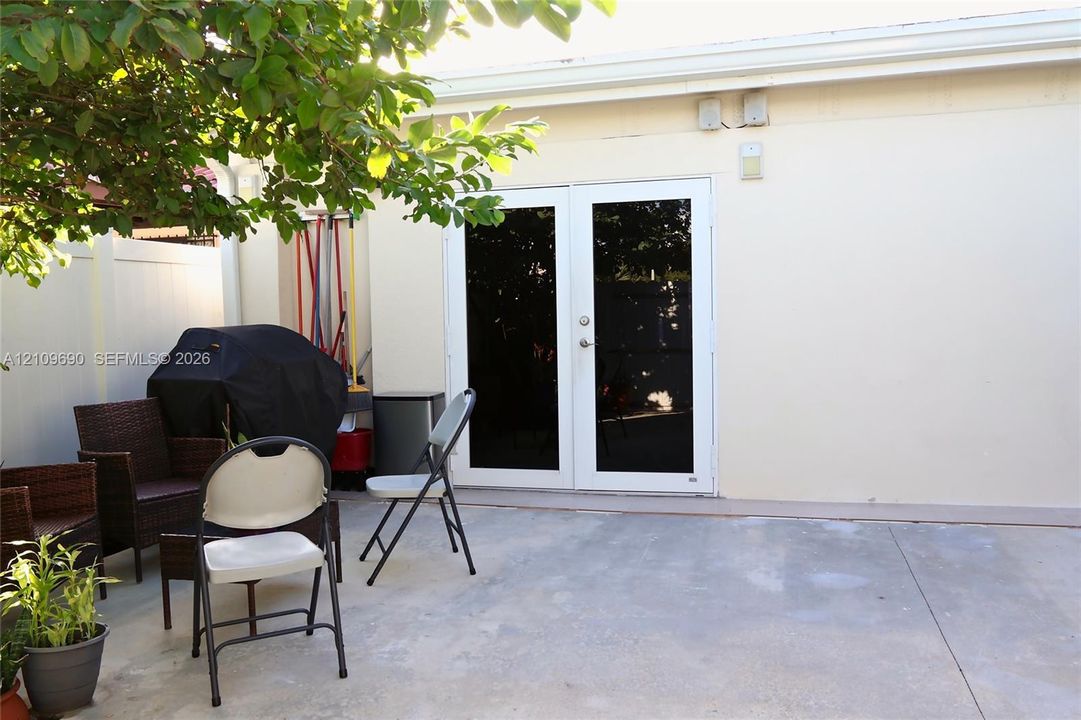 Concrete patio featuring white vinyl perimeter fencing and double glass-paned doors