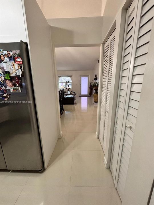 Large-format tile flooring, high ceilings, and floor-to-ceiling louvered-panel closet doors