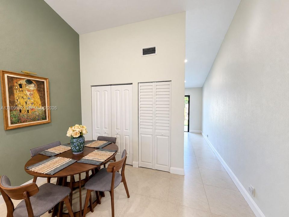 Vaulted ceilings, neutral tile flooring, and dual-panel closet doors with louvered accents