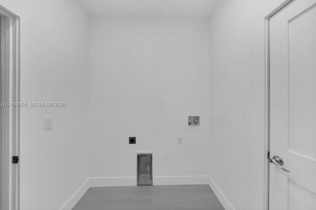 Dedicated utility space featuring neutral wall paint, wood-finish flooring, and recessed laundry hookups