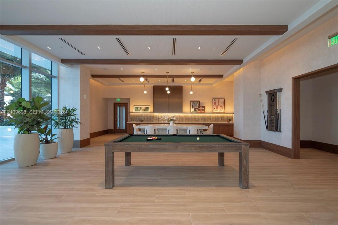 Open floor plan featuring wood-finish flooring, coffered ceiling with exposed wood beams, recessed lighting, and large glass windows