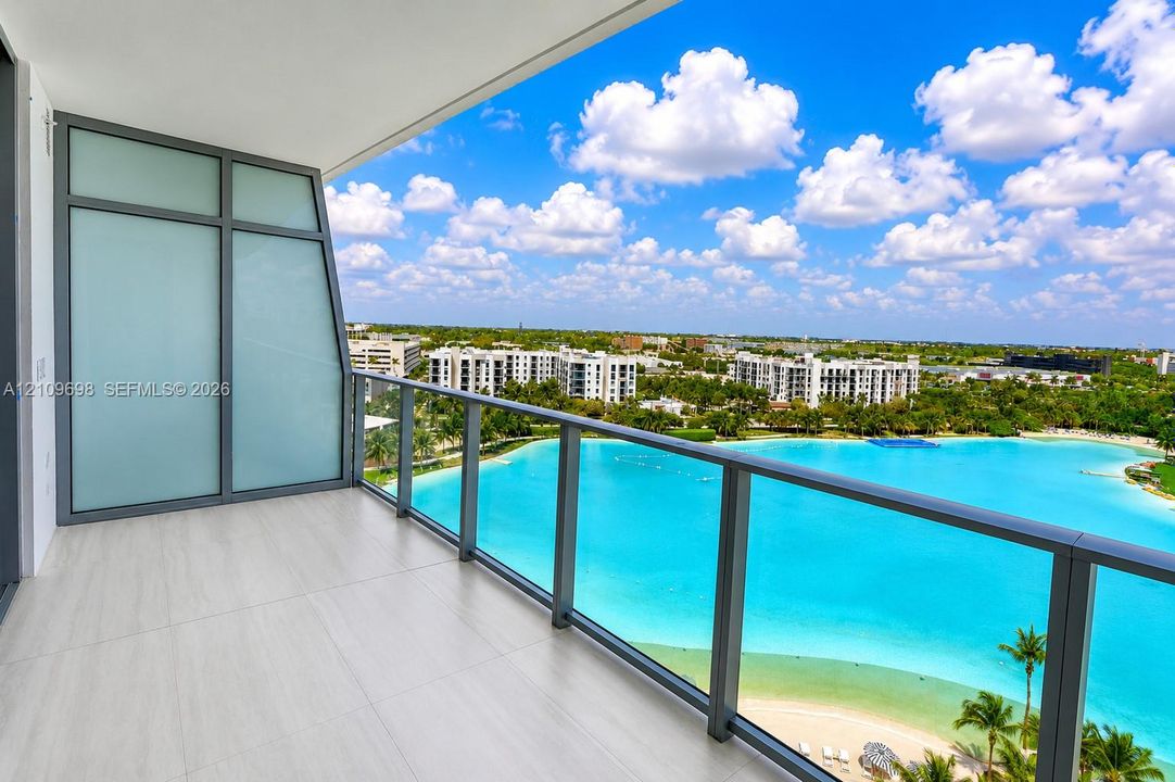 Private balcony featuring large-format tile flooring, a glass panel railing, and translucent privacy screening