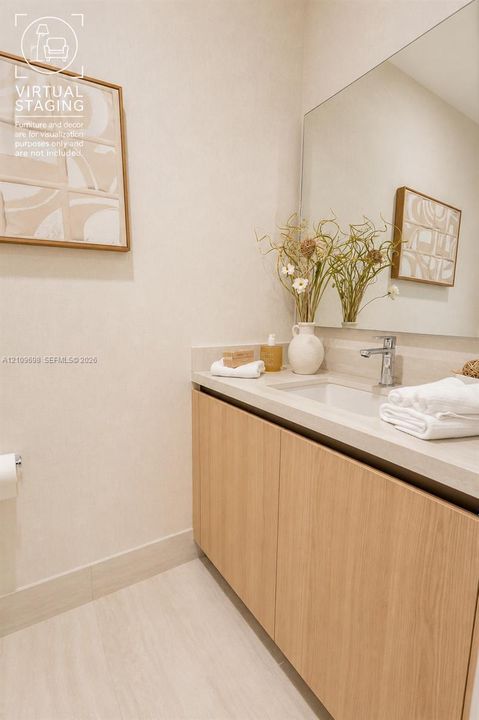 Floating vanity with light wood-finish cabinetry, stone-style countertop, integrated sink, chrome faucet, and expansive frameless wall mirror