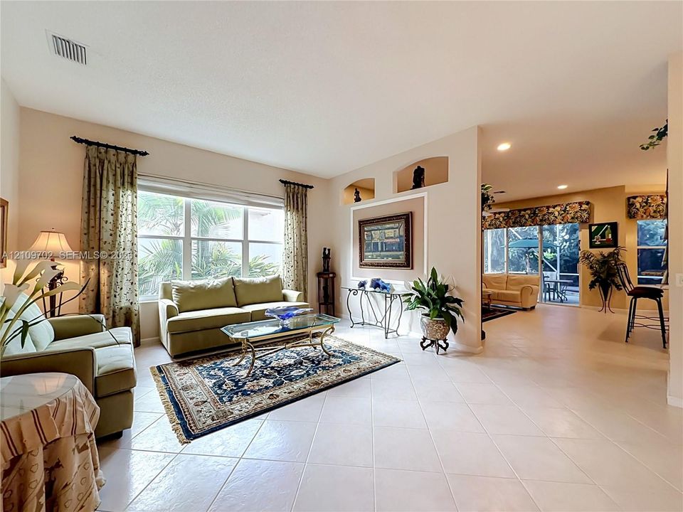 Living area featuring large windows, recessed wall niches, tile flooring, and sliding glass doors
