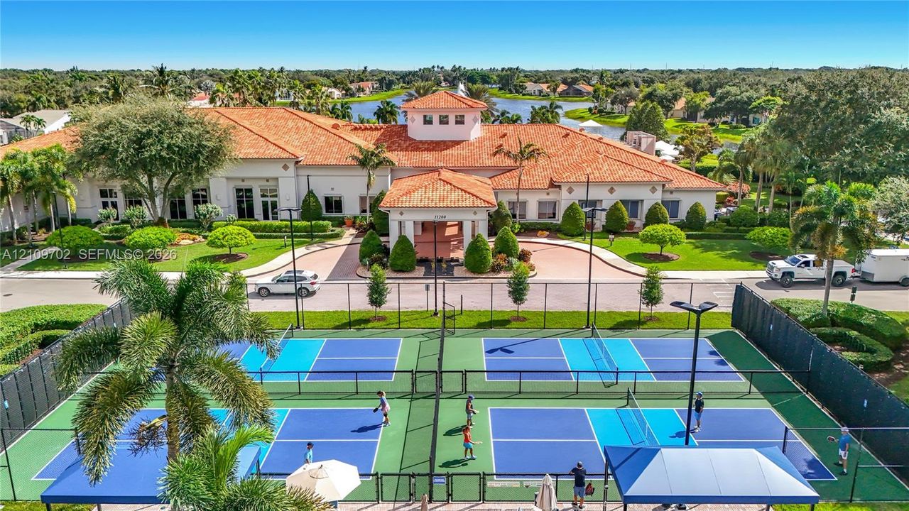 Multi-court pickleball facility featuring professional surfacing, perimeter fencing, overhead lighting, and covered spectator seating