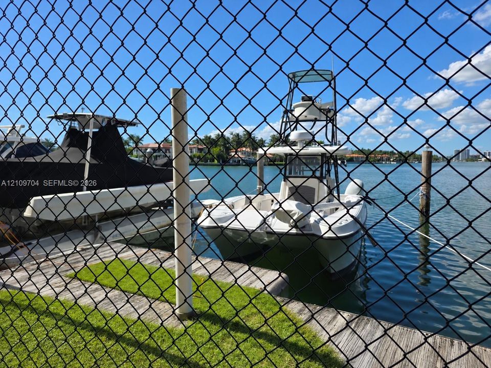 Waterfront property featuring a wooden bulkhead, piling moorings, and direct access to an expansive canal