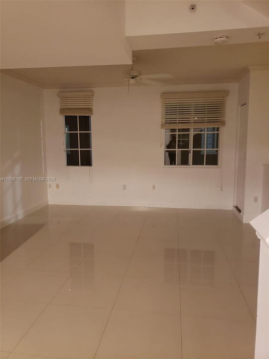 Large-format tile flooring, multi-pane windows, and a ceiling fan