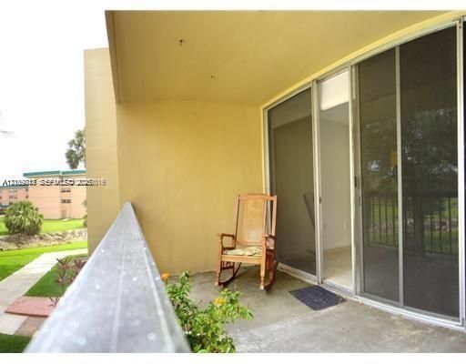 Covered balcony featuring concrete flooring, a metal railing, and aluminum-framed sliding glass doors