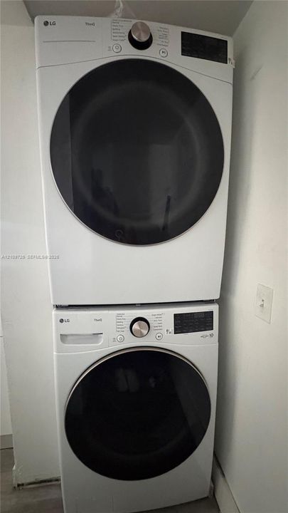 Stacked LG washer and dryer unit featuring white finish, front-loading doors, and digital control panels