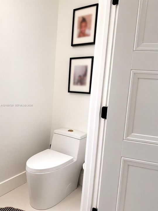 One-piece dual-flush toilet, solid-core three-panel interior door, and matte black door hardware