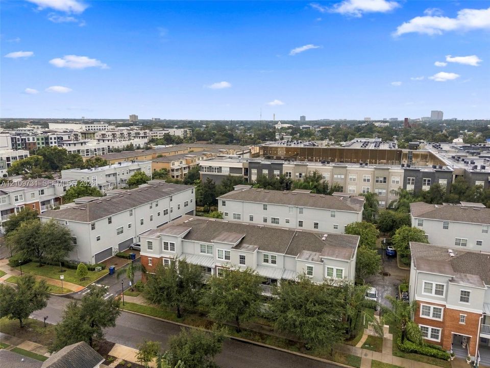 Multi-level townhome community featuring brick and siding facades, shingled roofing, attached garage parking, and manicured landscaping