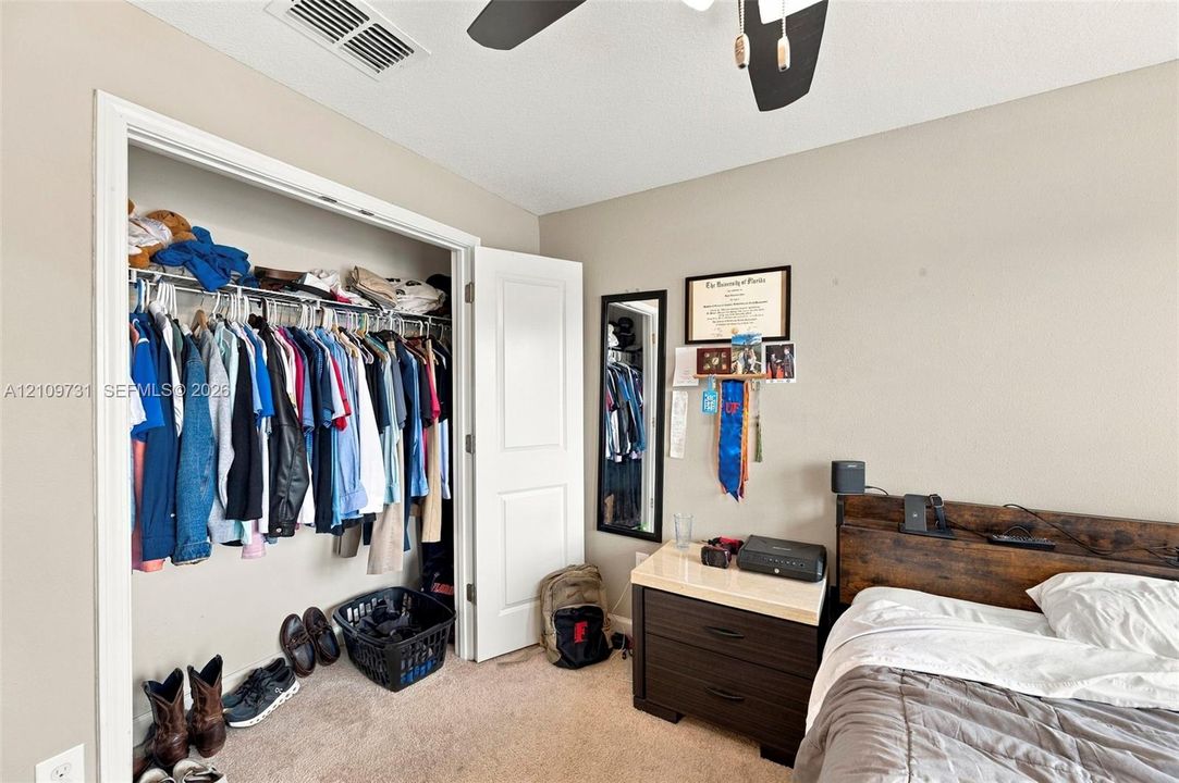 Walk-in closet featuring wire shelving, neutral carpeting, and a multi-panel interior door