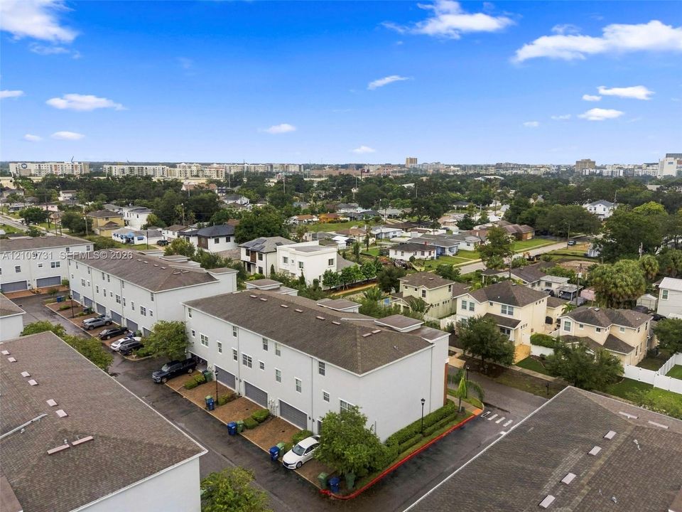 Multi-story townhome community featuring shingle roofing, exterior neutral siding, integrated garages, and paved driveways