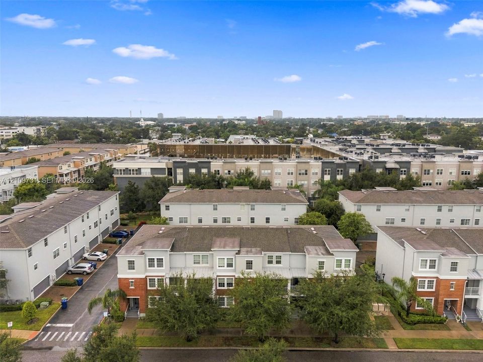 Multi-story townhome exterior featuring brick masonry detailing, shingled roofing, and private garage access