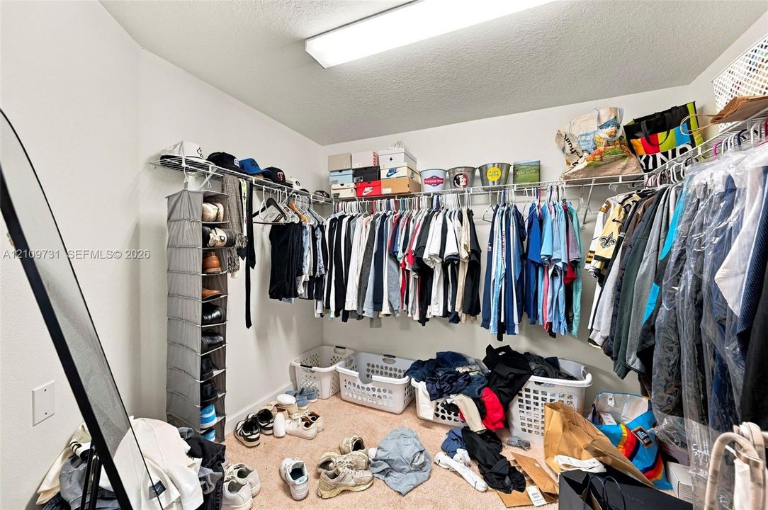 Walk-in storage space featuring continuous tiered wire shelving and flush-mount ceiling lighting