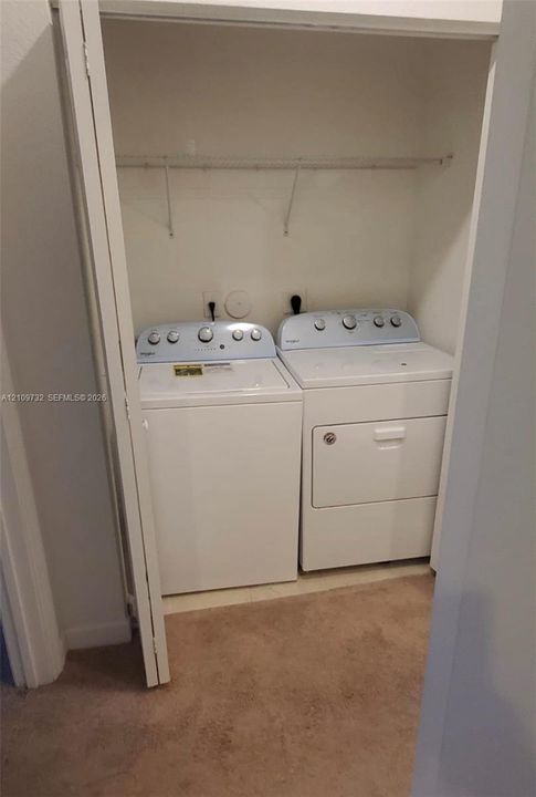 Laundry closet featuring a built-in wire shelf and hookups for a washer and dryer