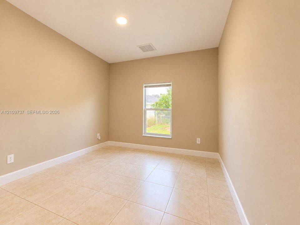 Neutral-toned room featuring ceramic tile flooring, recessed lighting, and a single window