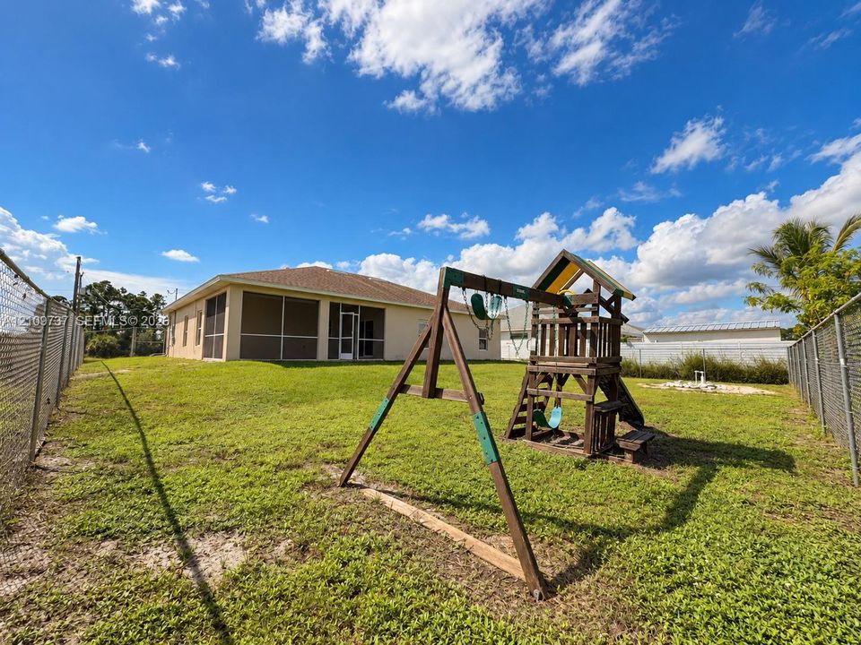 Spacious backyard featuring a screened-in rear porch and chain-link perimeter fencing