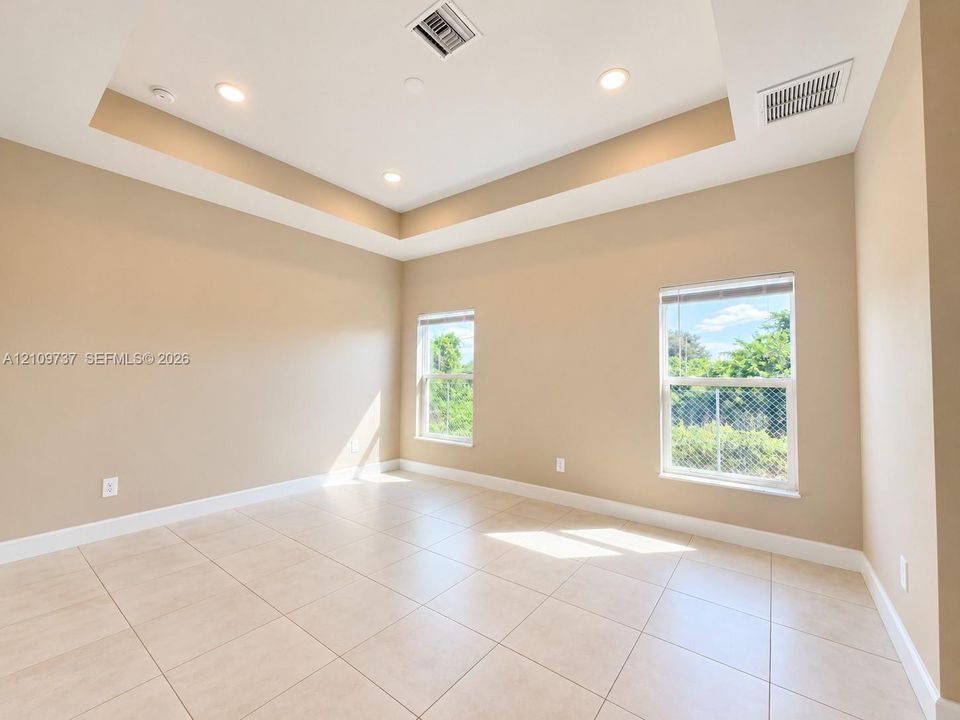 Tray ceiling featuring recessed lighting and tile flooring throughout