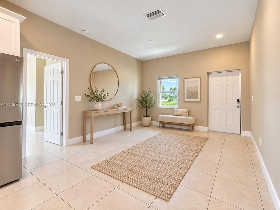 Neutral-toned interior space featuring light tile flooring, recessed lighting, and a six-panel exterior door