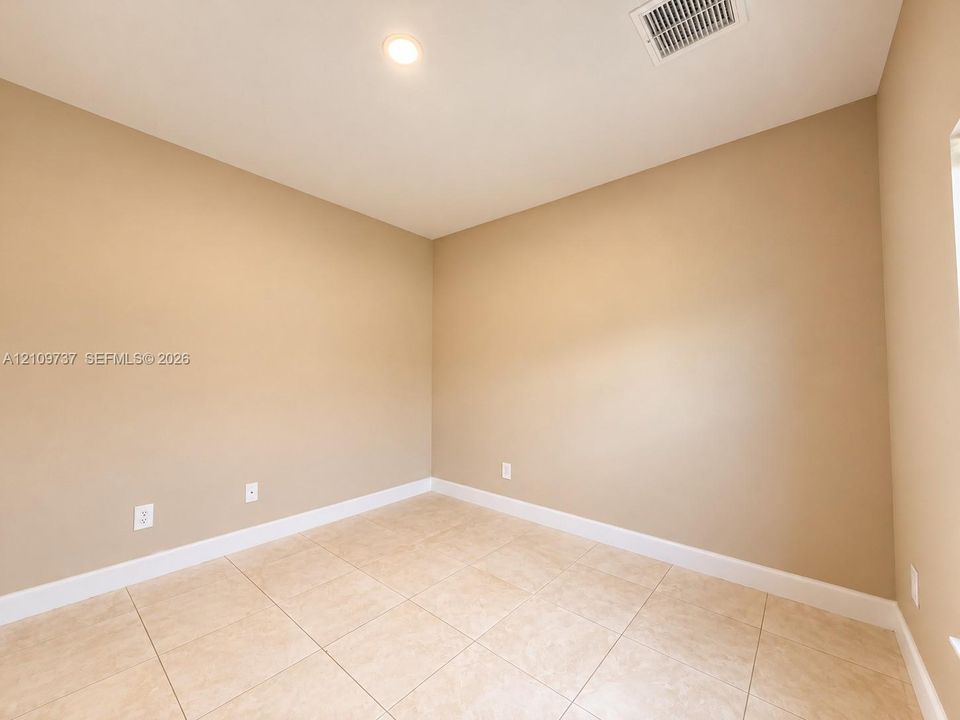 Neutral-toned walls featuring large-format ceramic tile flooring and recessed ceiling lighting