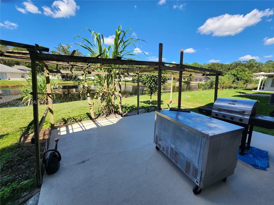 Concrete patio featuring a timber-frame pergola and a metal outdoor prep station