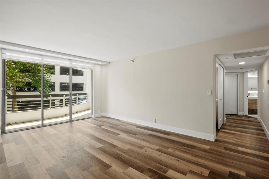 Wood-finish flooring, full-height sliding glass doors, and recessed ceiling lighting