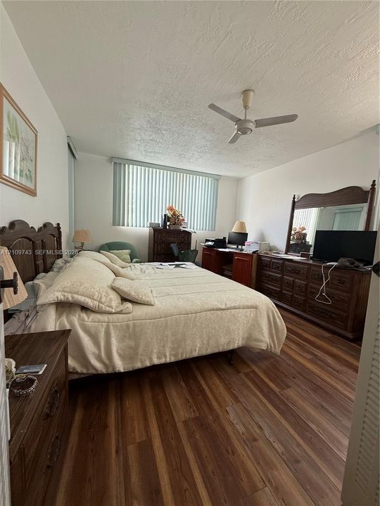 Wood-finish flooring, ceiling fan, and vertical blinds