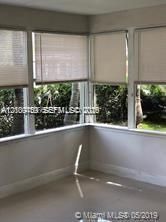 Sunroom featuring large windows, neutral wall tones, and pleated blinds