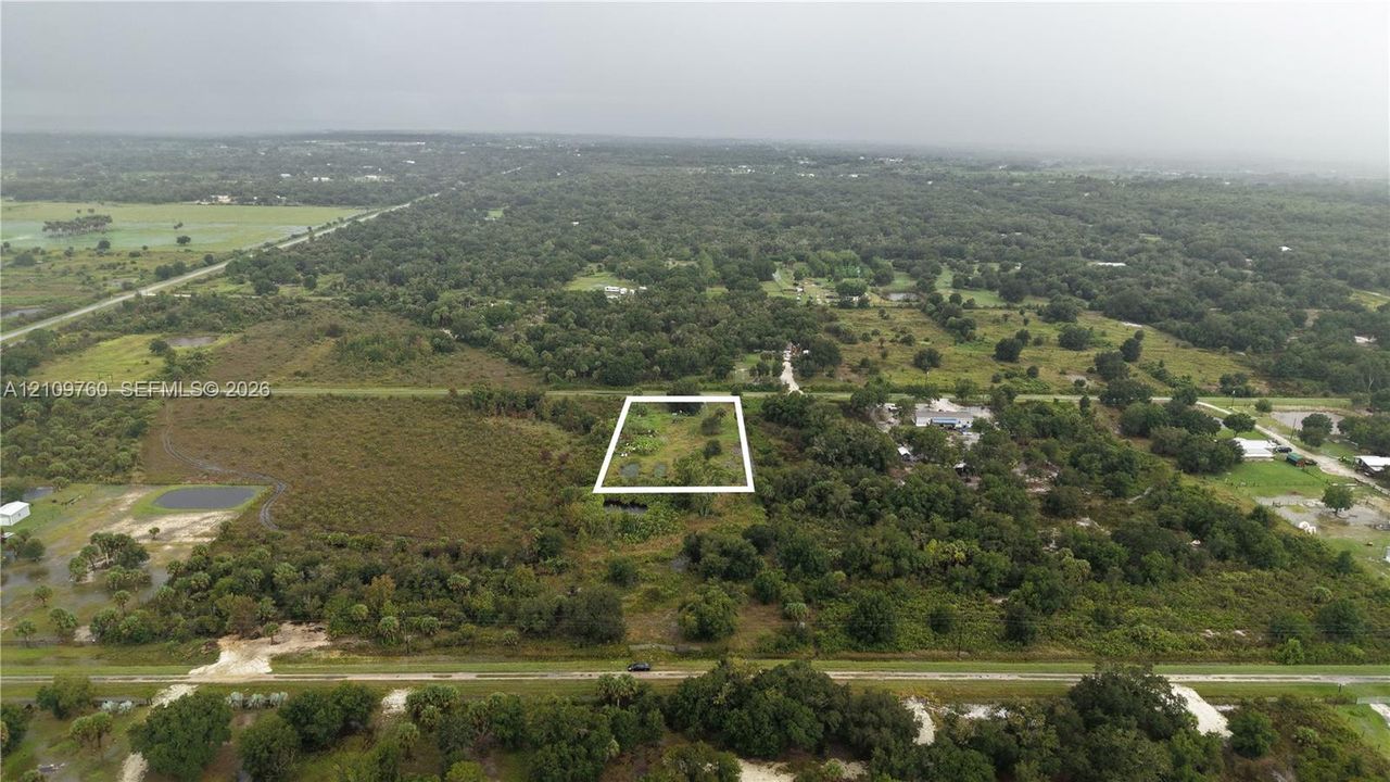 Aerial perspective of a parcel of land featuring mature trees and established natural vegetation
