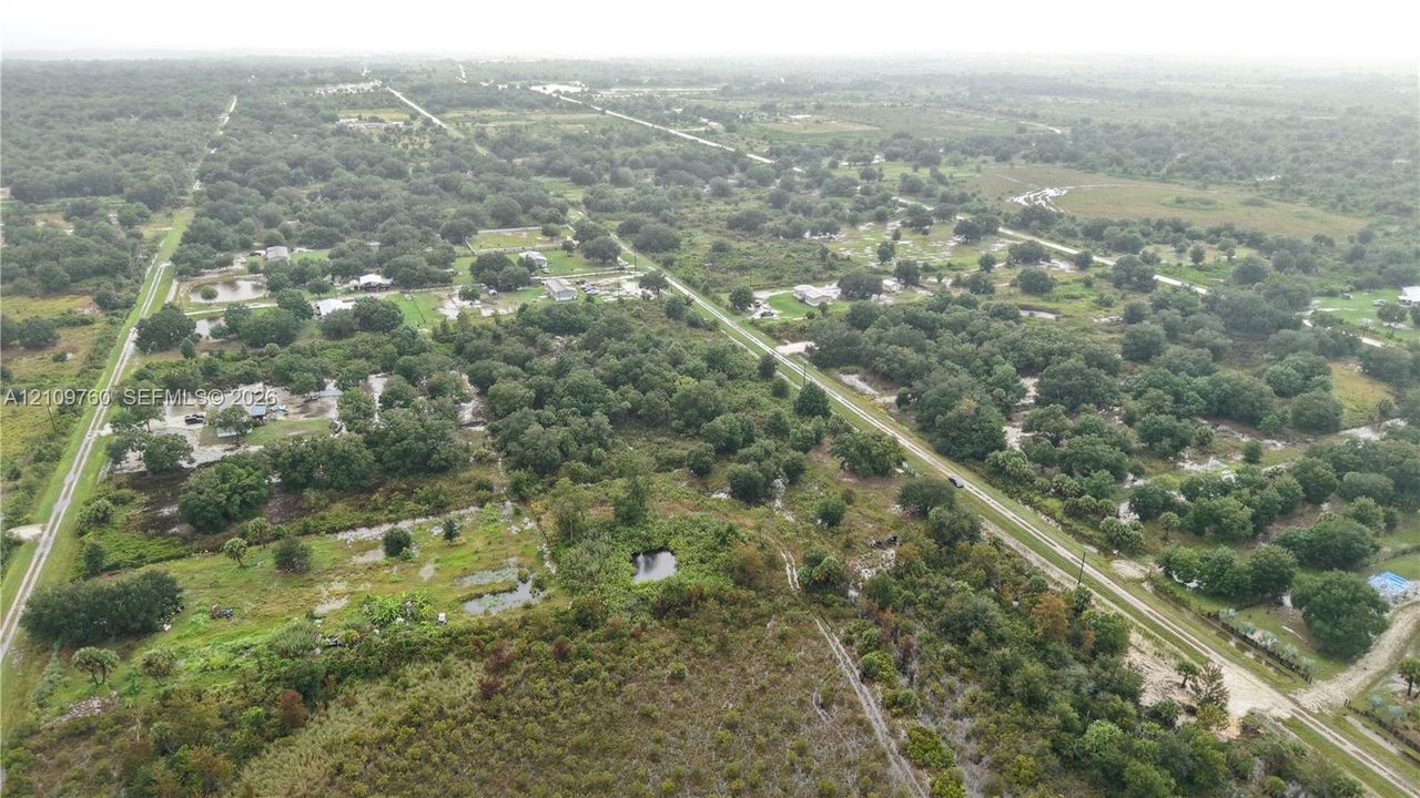 Aerial perspective of expansive acreage featuring mature trees, natural vegetation, and open land topography