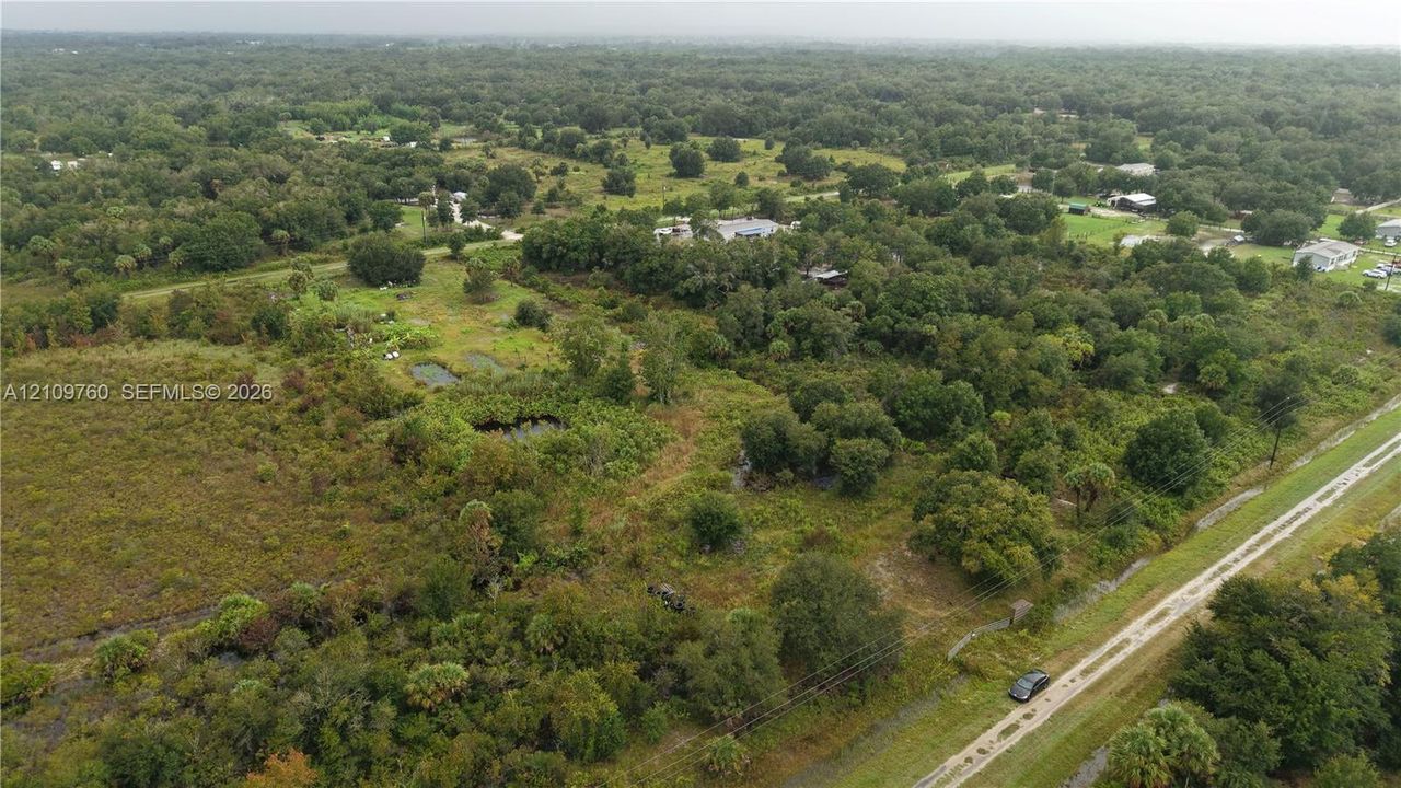 Expansive acreage featuring mature trees, diverse vegetation, open grassy areas, and natural ponds