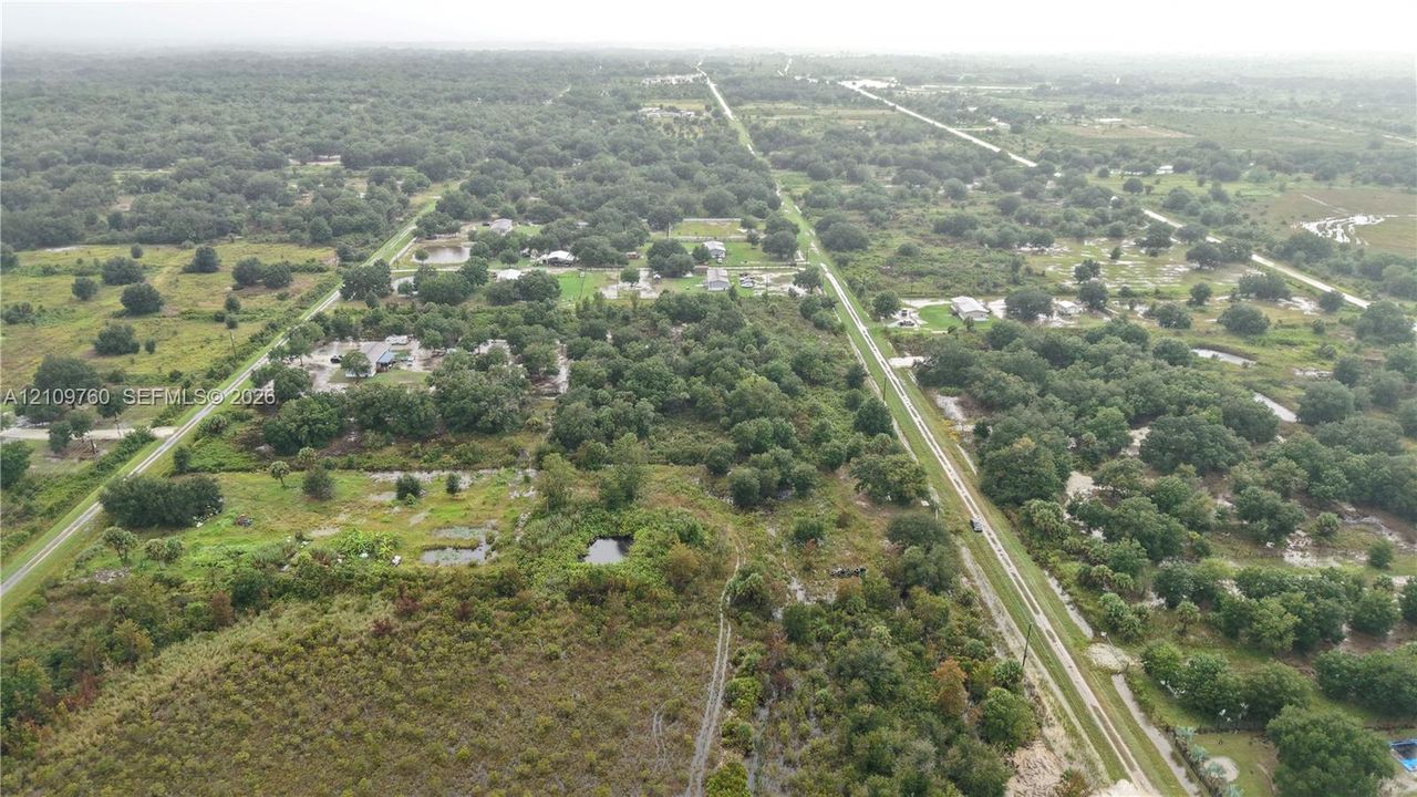 Aerial perspective of expansive acreage featuring mature trees, natural vegetation, and open land
