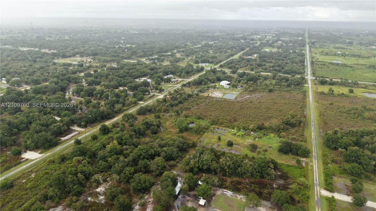 Expansive acreage featuring mature tree lines, open pastoral grounds, and direct access to paved public roadways