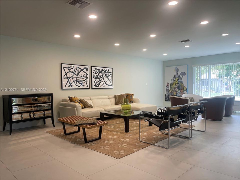 Neutral-toned ceramic tile flooring, recessed ceiling lighting, and vertical window blinds