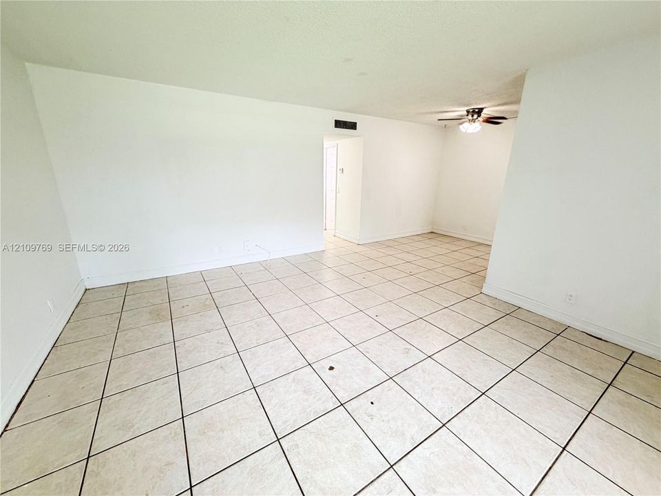 Interior space featuring large-format square tile flooring and a ceiling fan with integrated lighting