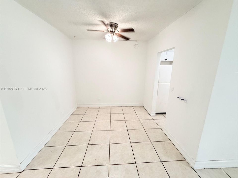 Interior area featuring tile flooring, neutral wall tones, and a ceiling fan with integrated light fixture