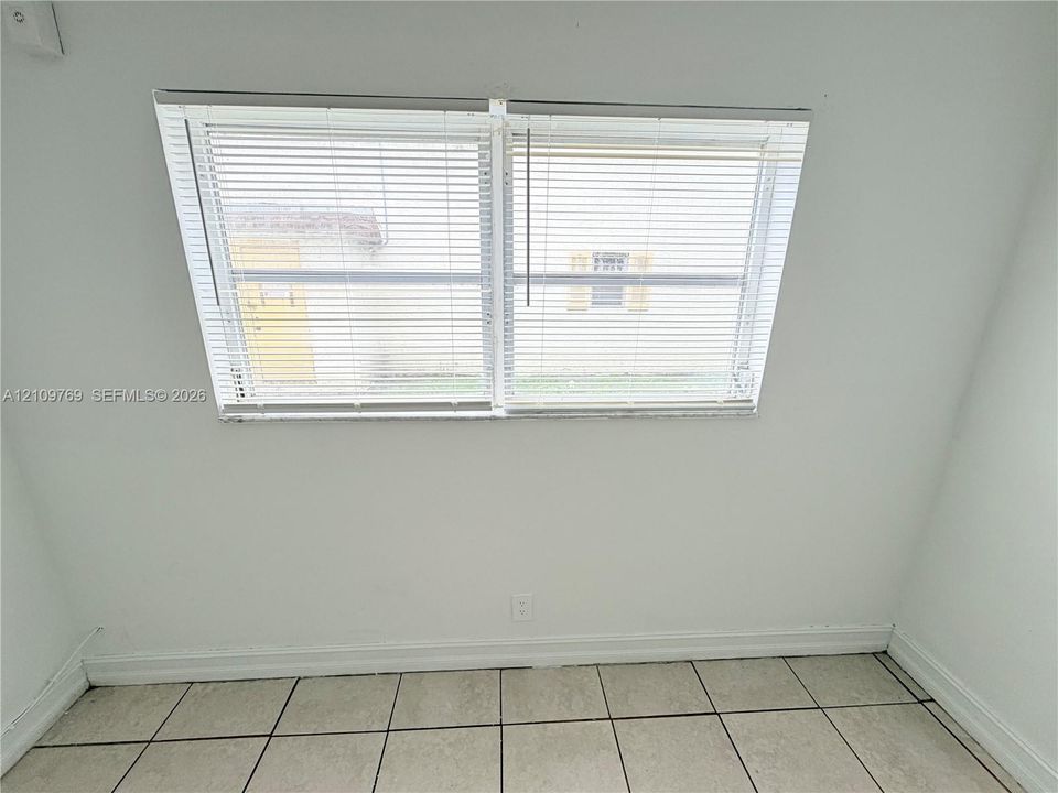 Dual-pane windows with horizontal blinds and neutral ceramic tile flooring