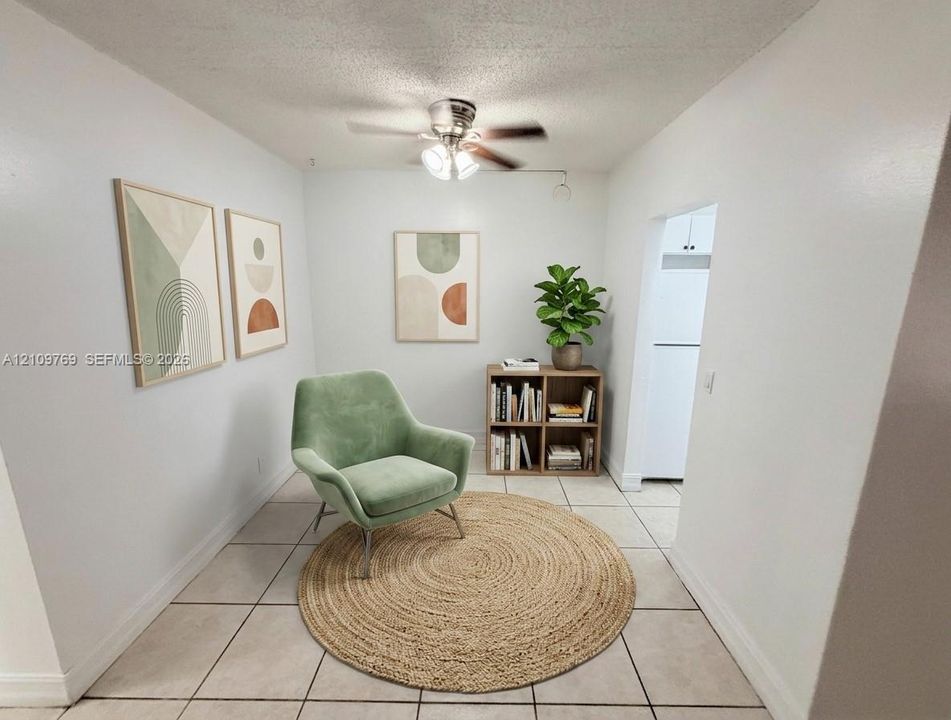 Interior space featuring light-toned tile flooring and a ceiling-mounted light fixture with a fan