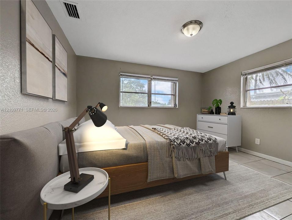 Neutral-toned interior space featuring light-colored tile flooring, multiple windows, and a flush-mount ceiling light fixture