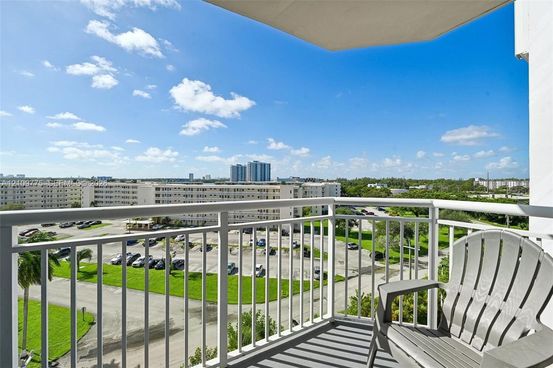 Private balcony with white metal railings and concrete flooring