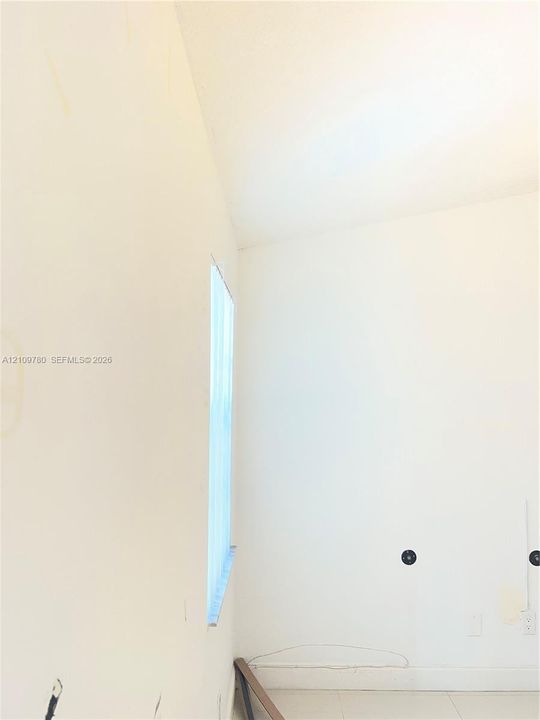 Interior space featuring neutral wall finish, vertical window, and light-toned flooring
