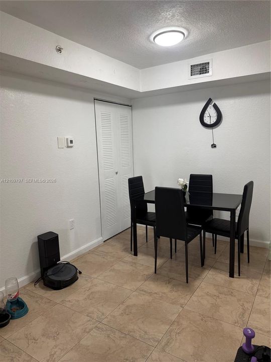 Neutral-tone tile flooring and closet with white louvered doors