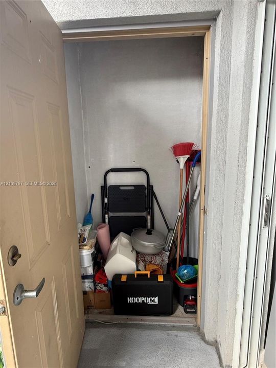 Enclosed storage unit featuring a metal-lever door handle and concrete flooring