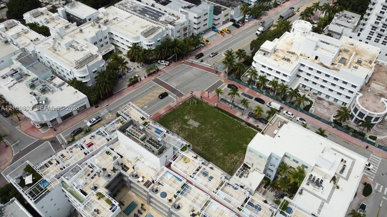 Corner lot featuring open green space situated at a street intersection within an urban district