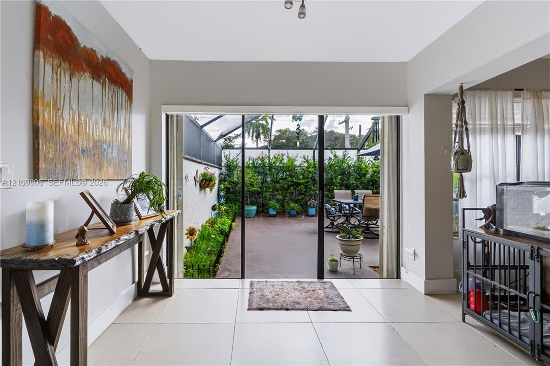 Interior featuring large-format tile flooring and sliding glass doors opening to a screened patio