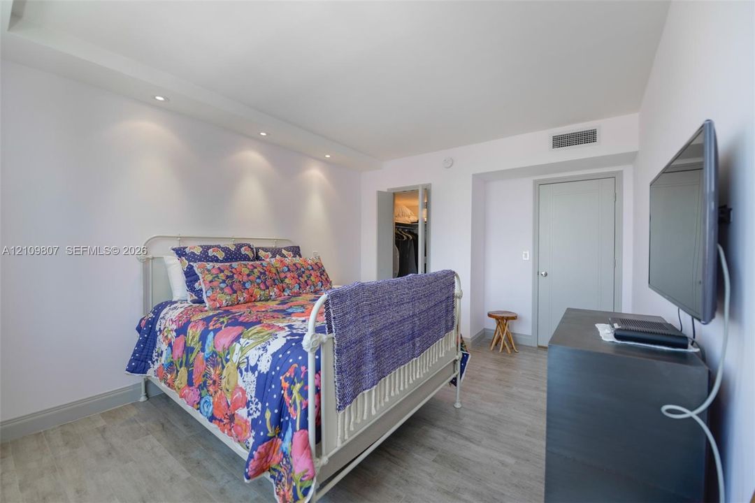 Interior space featuring wood-finish flooring, recessed ceiling lighting, and a reach-in closet with double doors