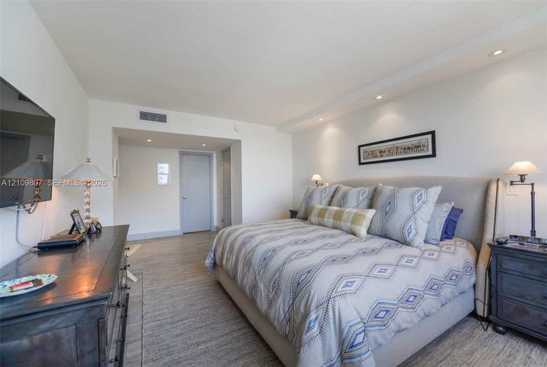 Neutral interior space featuring recessed ceiling lighting and wood-finish flooring