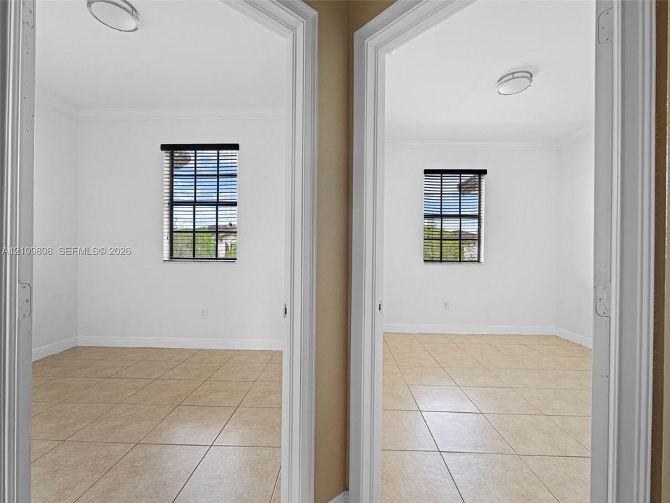 Interior spaces featuring arched doorways, light-toned ceramic tile flooring, neutral walls, and windows with integrated grid patterns