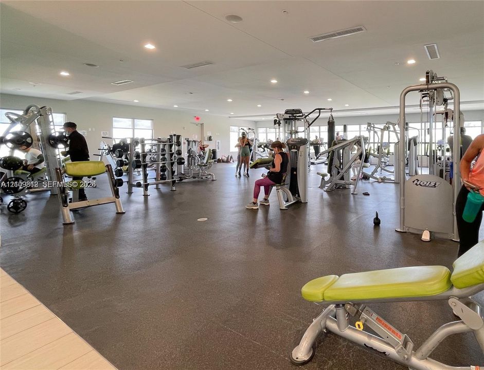 Fitness center featuring rubberized flooring, recessed lighting, and a wide range of strength training equipment